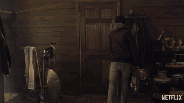 a man walking into a room with a netflix logo