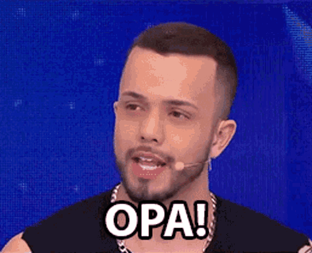 a man with a beard is talking into a microphone with the word opa on his face