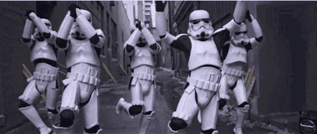 a group of stormtroopers are jumping in the air with their arms outstretched