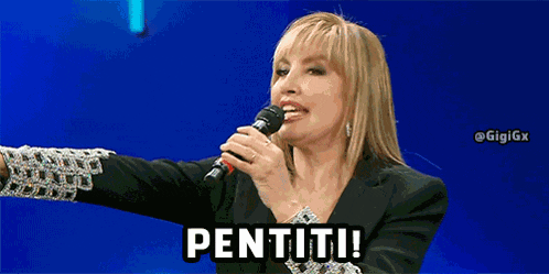 a woman singing into a microphone and pointing with the word pentiti above her