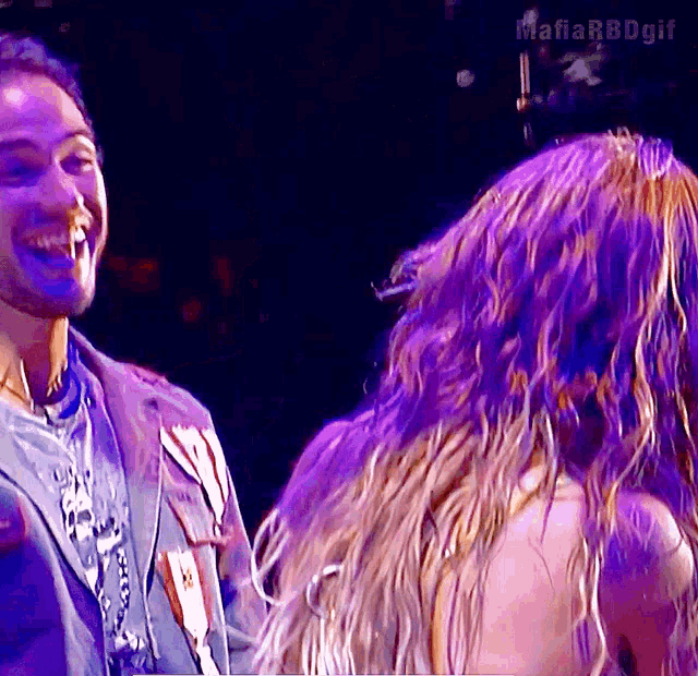 a man and a woman are laughing in front of a purple background with the hashtag mafia rbdgif
