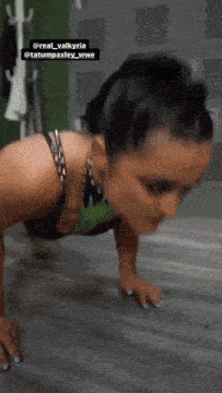 a woman is doing push ups in a locker room with a caption that says real valkyria tatumpaxley_wwe