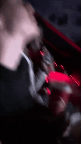 a blurry picture of a person holding a red object in a dark room