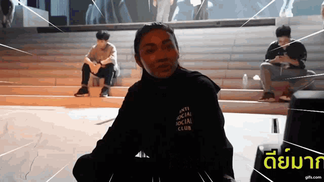 a woman wearing a black anti social social club sweatshirt