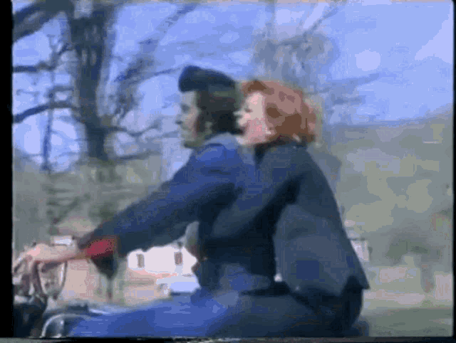 a man and a woman are riding a bike together