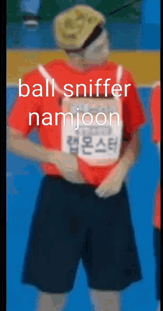 a person wearing a red shirt and black shorts with the words ball sniffer namjoon written on the bottom