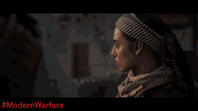 a man with a scarf around his neck is standing in front of a wall with #modernwarfare written on the bottom