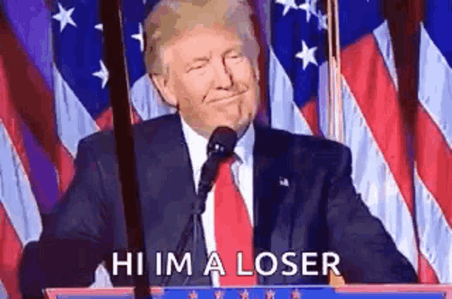 donald trump is giving a speech at a podium in front of american flags .