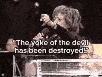 a woman singing into a microphone with the words " the yoke of the devil has been destroyed " behind her