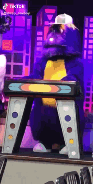 a person in a sesame street costume stands on a ladder