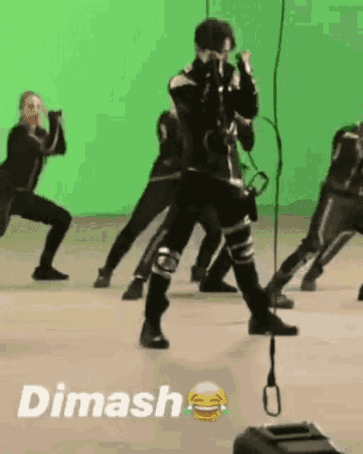 a group of people are dancing on a green screen in front of a green background .