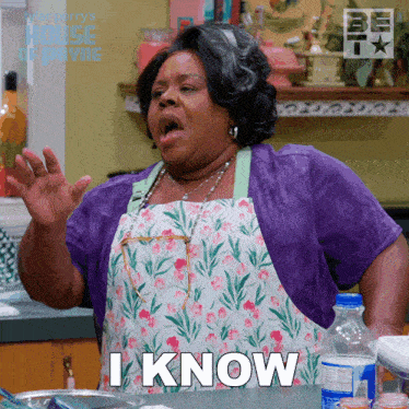 a woman wearing an apron and a purple shirt says i know