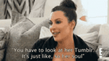 kim kardashian is sitting on a couch and smiling while talking to someone on tumblr .
