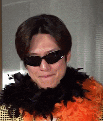 a man wearing sunglasses and an orange boa