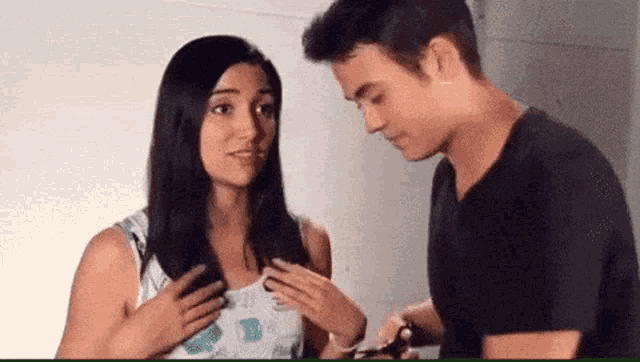 a man and a woman are standing next to each other and talking .