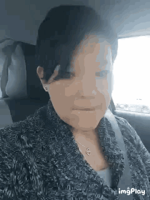 a woman is sitting in the back seat of a car wearing a seat belt .