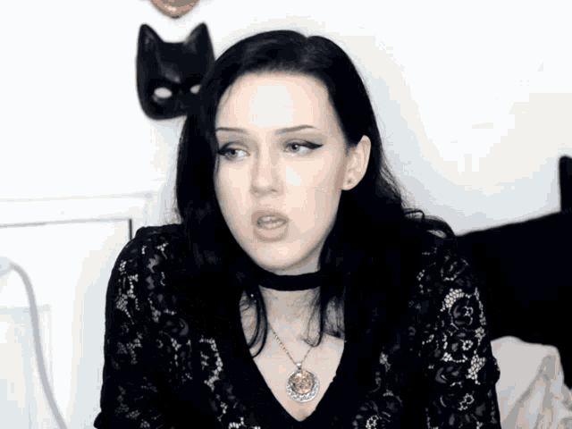 a woman wearing a choker and a necklace with a pendant