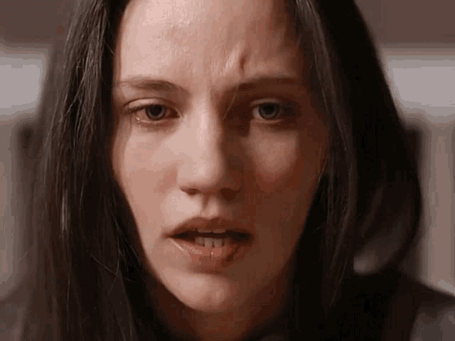 a close up of a woman 's face with a tear coming out of her eye