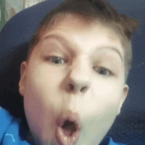 a young boy is making a funny face with his mouth wide open