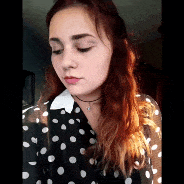 a woman wearing a black and white polka dot shirt
