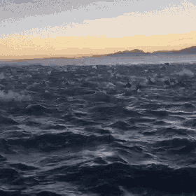 a large body of water with a mountain in the background