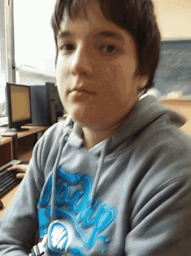 a young boy wearing a hoodie with the word tango on it looks at the camera