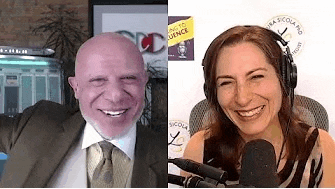 a man in a suit and tie is smiling next to a woman in headphones .