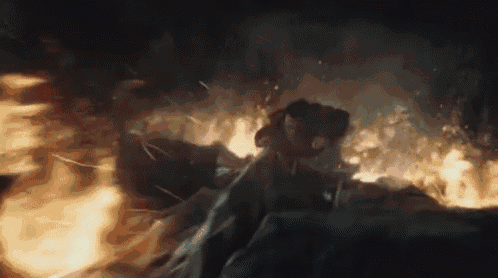 a man is flying through the air in front of a fire in a cave .