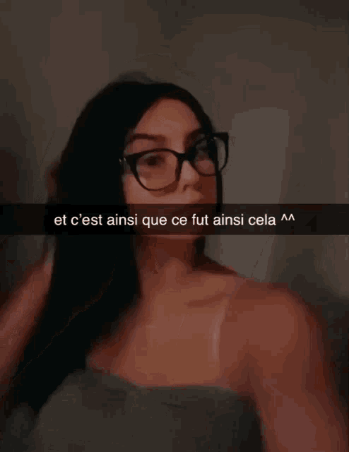 a woman wearing glasses is taking a selfie with a caption in french