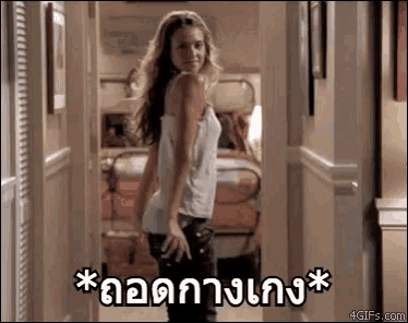 a woman in a white tank top is standing in a hallway with a foreign language .