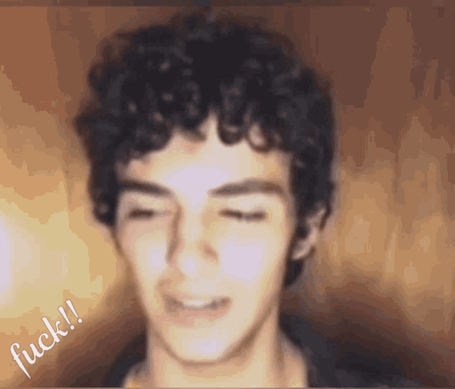 a blurry picture of a man with curly hair and the word fuck on the bottom right