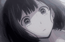 a close up of a crying anime girl with tears running down her face .