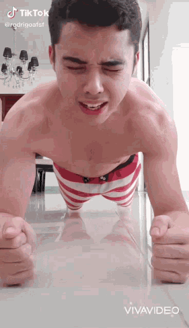 a shirtless man is doing push ups on the floor