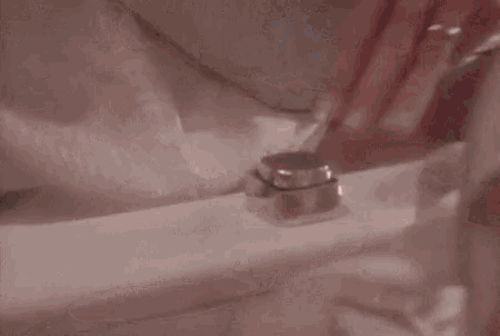 a woman with red nails is adjusting a faucet on a toilet