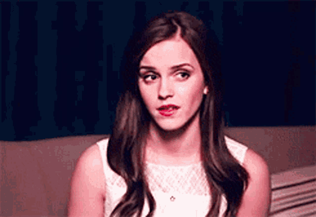 a woman is sitting on a couch looking at the camera .