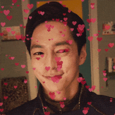 a man with hearts coming out of his eyes looks at the camera