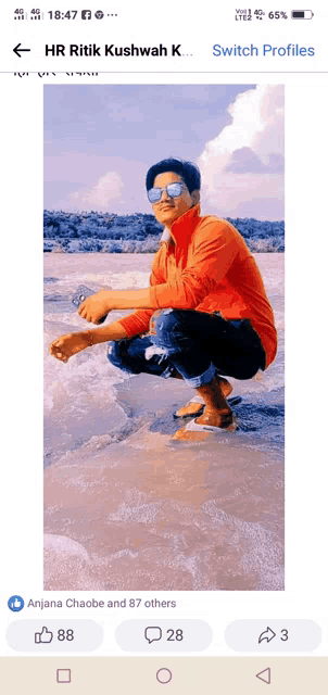 a phone screen shows a picture of a man squatting in the water