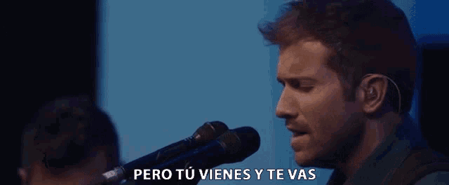 a man singing into a microphone with the words pero tu vienes y te vas written below him