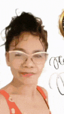 a woman wearing glasses and a red tank top smiles