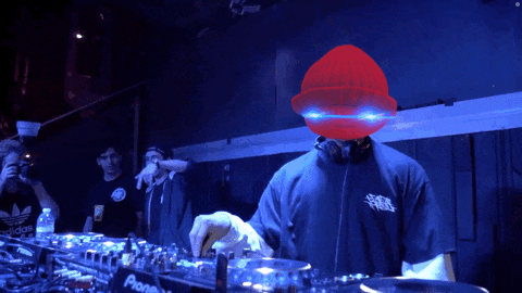 a man wearing headphones and a hard hat is playing music on a pioneer mixer