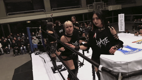 a woman wearing a black shirt that says hate stands next to another woman