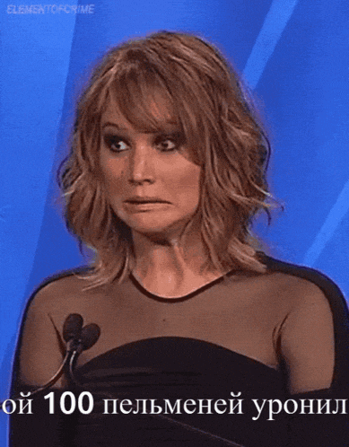 a woman in a black dress stands in front of a microphone with a foreign language caption