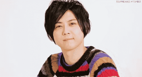 a young man wearing a striped sweater is smiling .