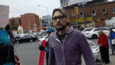 a man in a purple jacket is walking down a street with a sign that says about kids