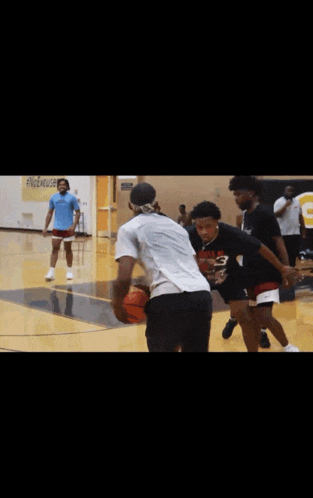 a group of people are playing basketball in a gym with a sign that says g on it