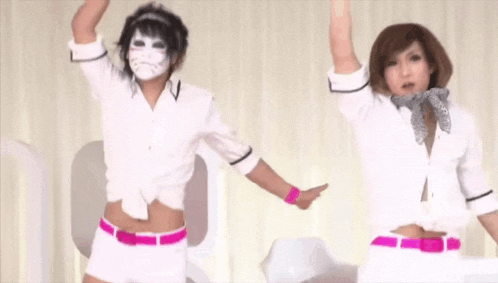 a man and a woman wearing white shirts and pink belts are dancing