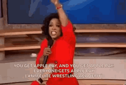 a woman in a red dress is holding a microphone and saying you get apple pay and you get apple pay everyone gets apple pay