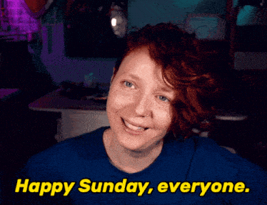 a woman in a blue shirt is smiling and says " happy sunday everyone "