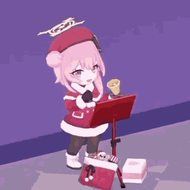 a girl in a santa suit is standing next to a laptop and a box .