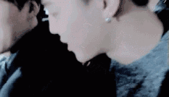 a close up of a person 's face with a man behind her .